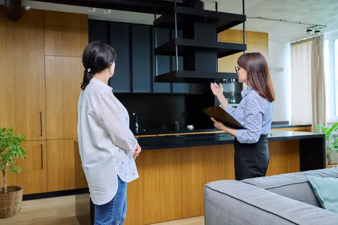 Mujer comercial enseñando el piso para comprar a otra mujer